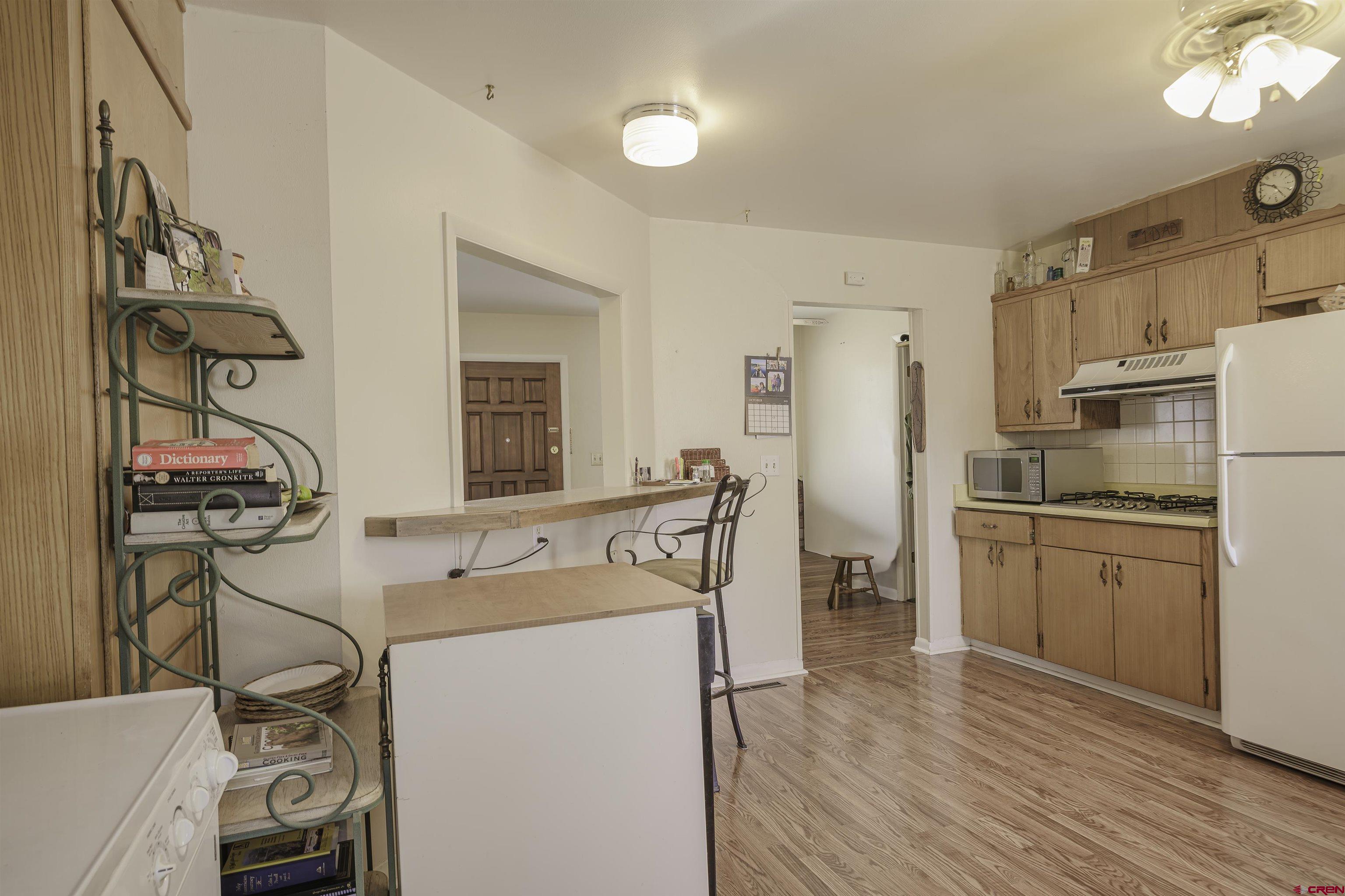 1002 East 2nd Street Florence, CO 81226 - Photo 14 of 44 a kitchen with refrigerator cabinets and wooden floor