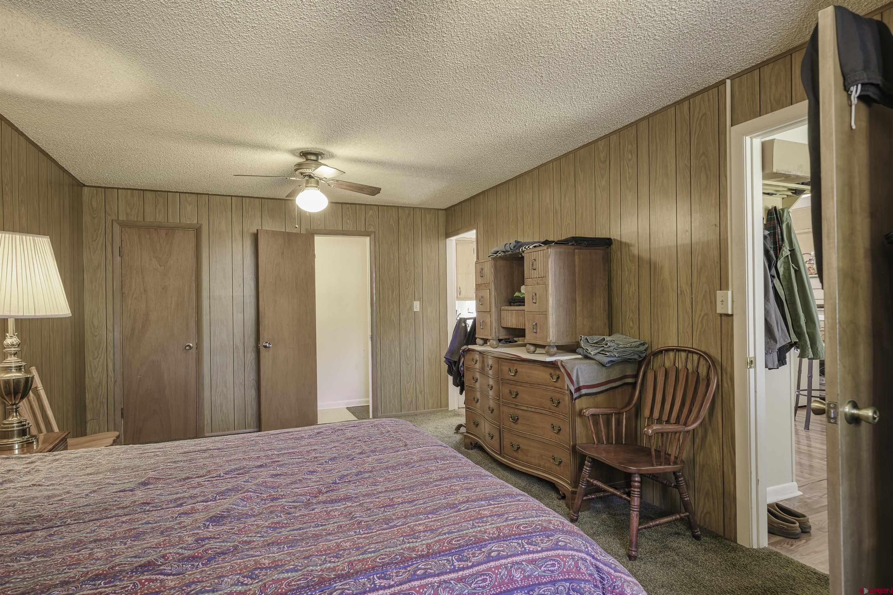 1002 East 2nd Street Florence, CO 81226 - Photo 16 of 44 a spacious bedroom with a bed and a chandelier