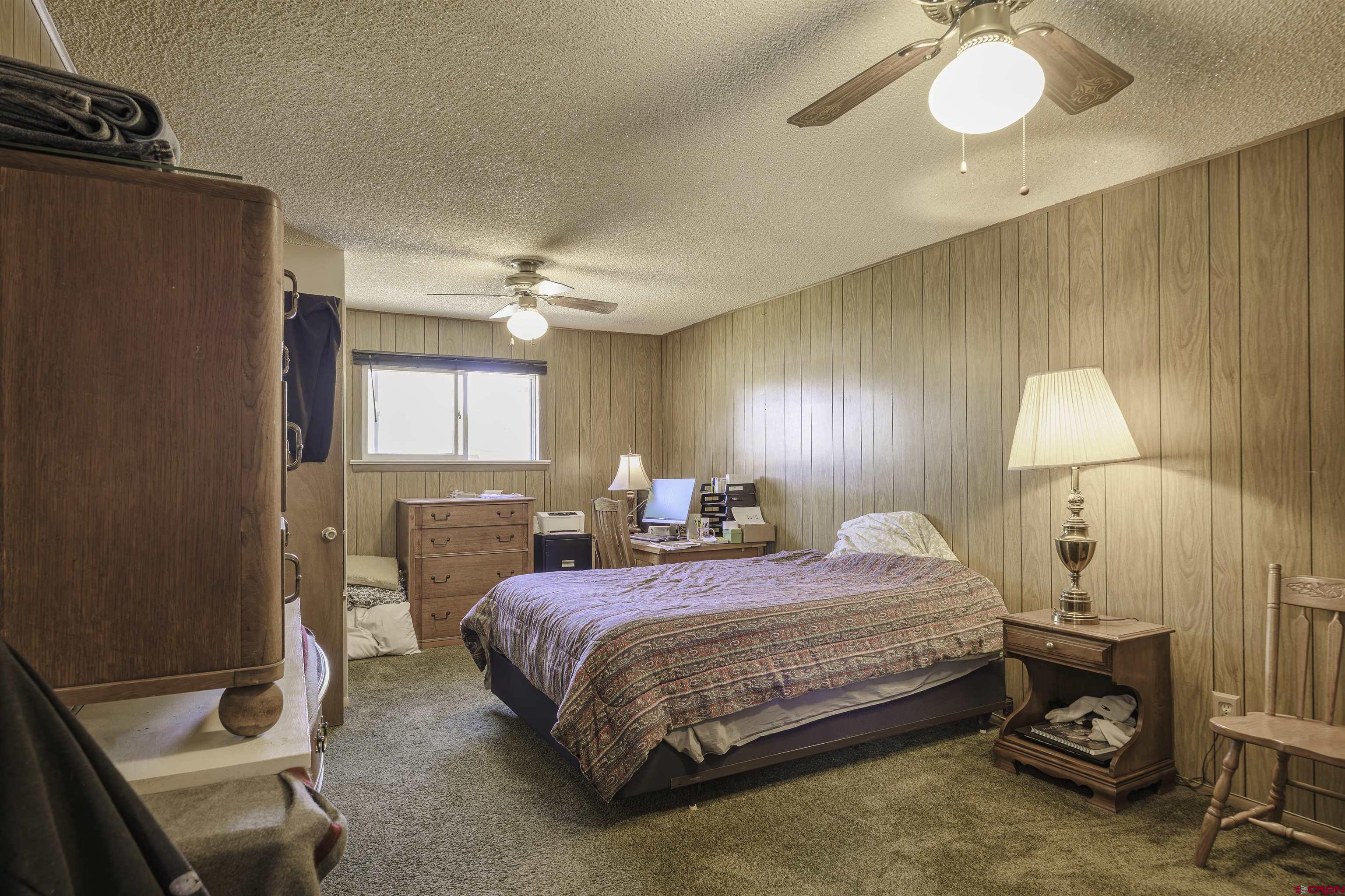 1002 East 2nd Street Florence, CO 81226 - Photo 18 of 44 a bedroom with a bed and a chandelier