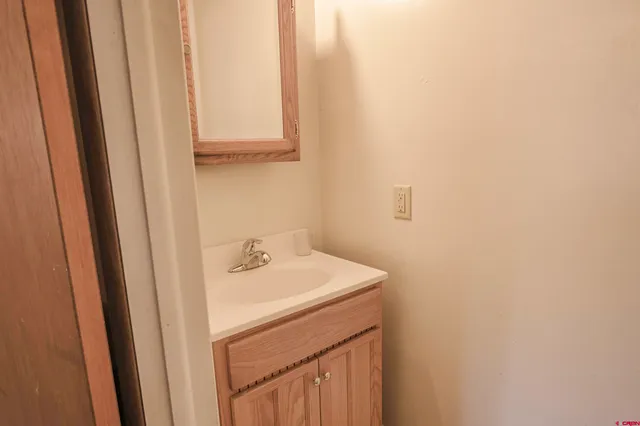 a bathroom with a granite countertop toilet and a sink