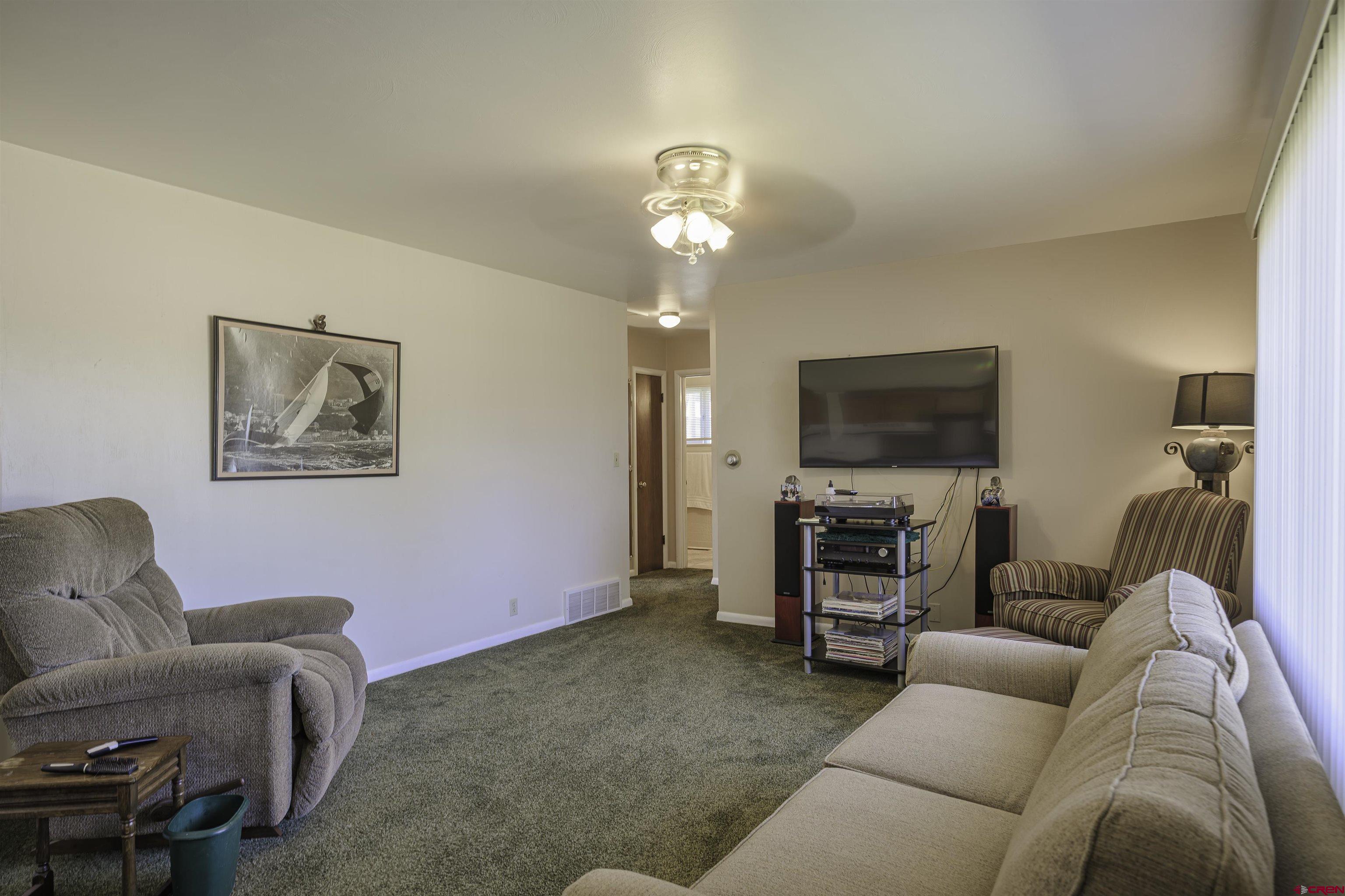 1002 East 2nd Street Florence, CO 81226 - Photo 5 of 44 a living room with furniture a flat screen tv and a fireplace