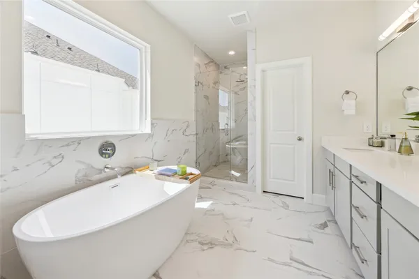 a bathroom with a tub a sink and a mirror