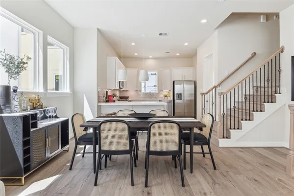 a kitchen with stainless steel appliances granite countertop a dining table chairs stove refrigerator and cabinets