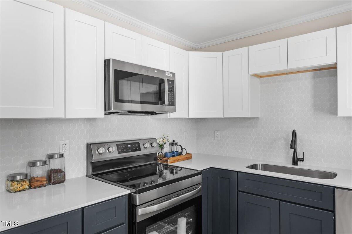 2304 Nelson Street Raleigh, NC 27610 - Photo 12 of 23 a kitchen with cabinets appliances a sink and a counter space