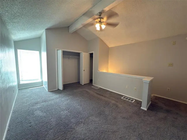 a view of an empty room with a chandelier fan