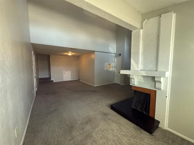 an empty room with a fireplace and cabinet
