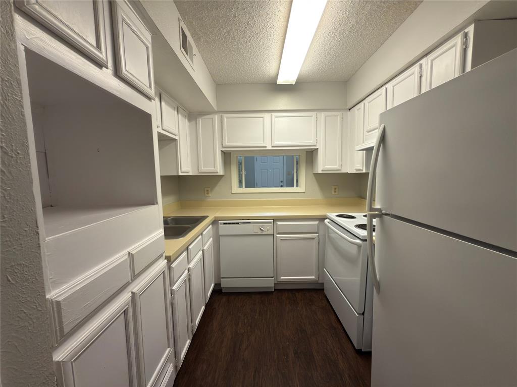 9696 Walnut Street, Unit 1108 Dallas, TX 75243 - Photo 7 of 19 a kitchen with a sink a refrigerator and cabinets