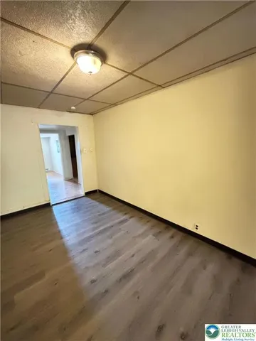 a view of empty room with wooden floor