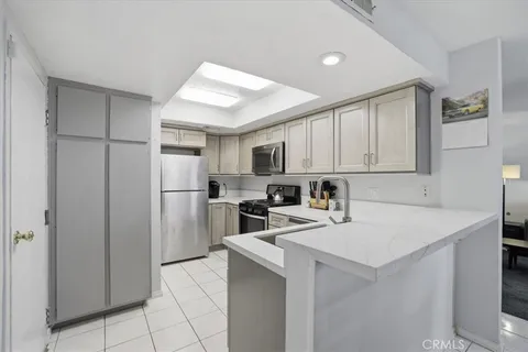 a kitchen with a refrigerator a stove top oven a sink and cabinets
