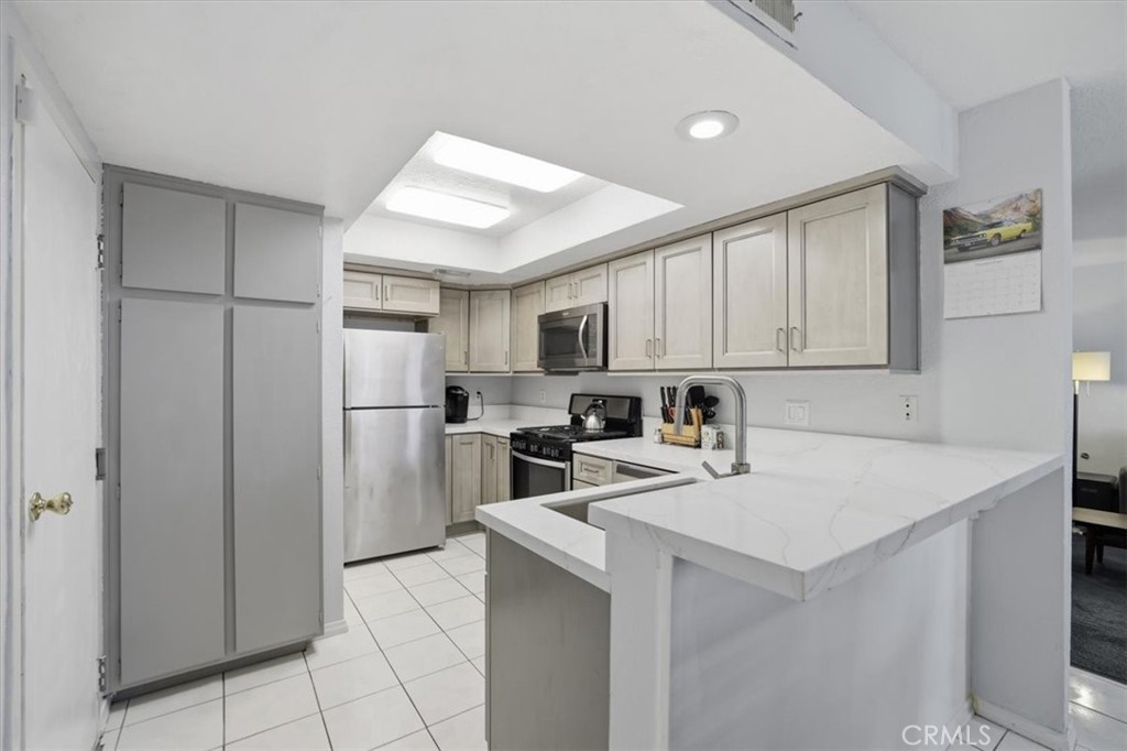 9743 La Jolla Drive, Unit D Rancho Cucamonga, CA 91701 - Photo 14 of 40 a kitchen with a refrigerator a stove top oven a sink and cabinets
