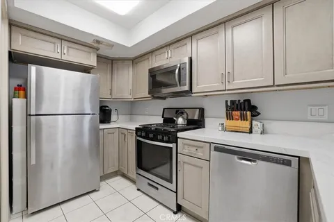 a kitchen with stainless steel appliances granite countertop a refrigerator a microwave a sink and cabinets