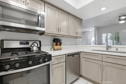a kitchen with cabinets stainless steel appliances and a sink