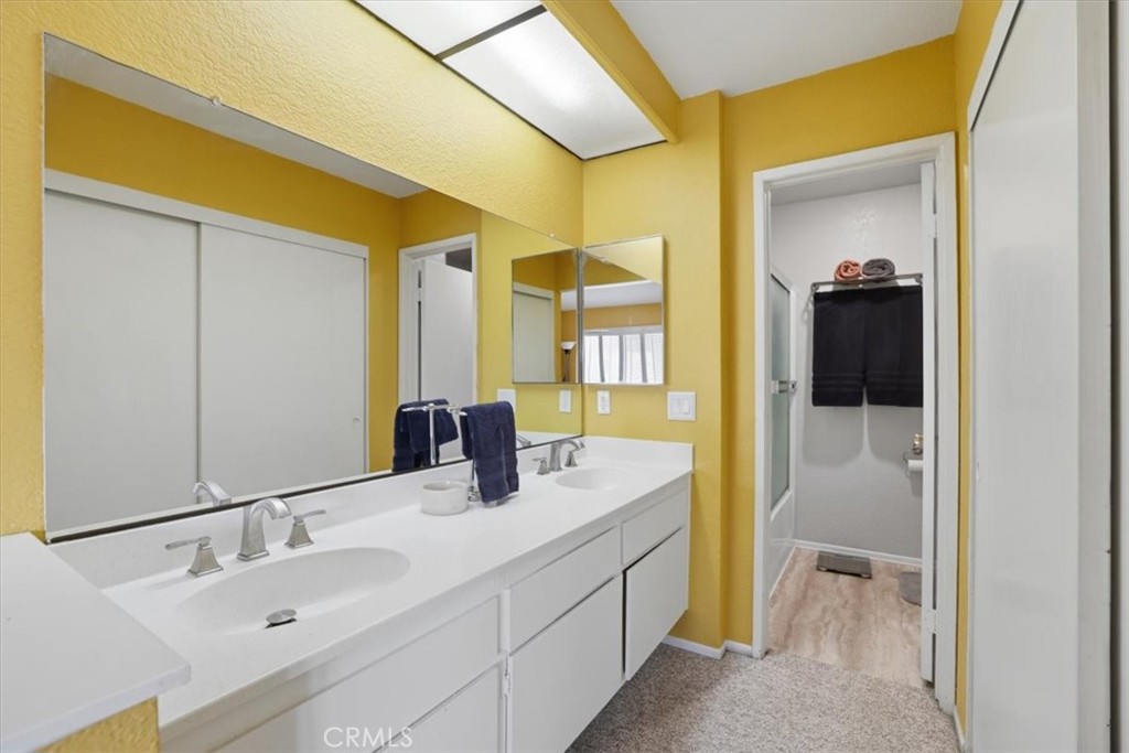 9743 La Jolla Drive, Unit D Rancho Cucamonga, CA 91701 - Photo 23 of 40 a bathroom with a granite countertop sink and a mirror