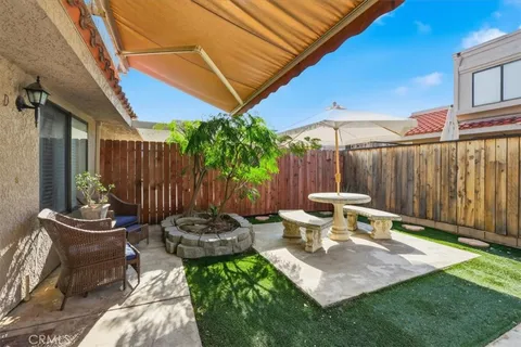 a view of a backyard with table and chairs potted plants and floor
