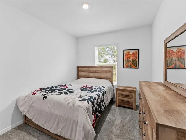 a bedroom with a bed and painting on the wall