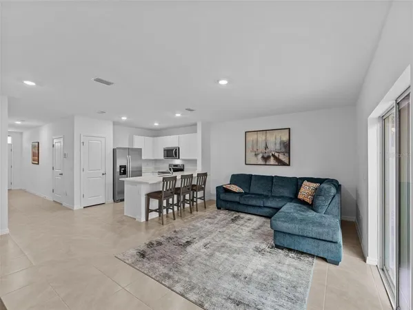 a living room with furniture and a dining table with kitchen view