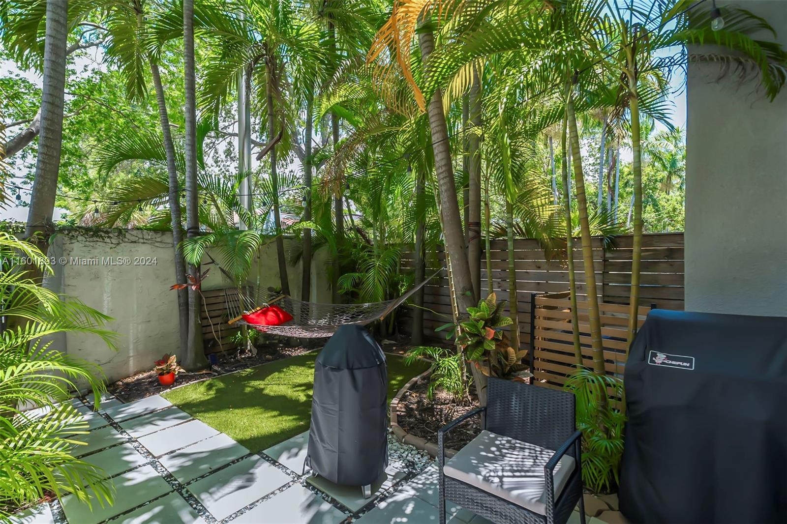3204 Bird Avenue, Unit 109 Miami, FL 33133 - Photo 39 of 67 a backyard of a house with lots of green space and a fountain