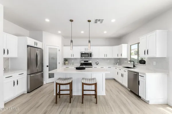 a kitchen with white cabinets and stainless steel appliances