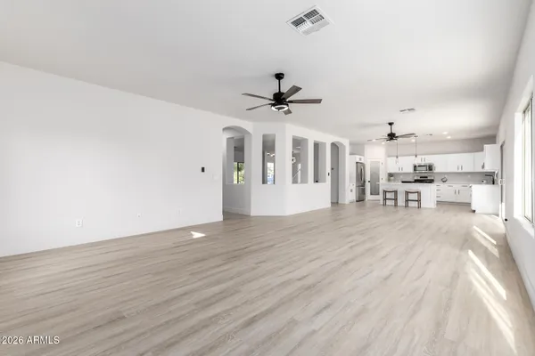 a kitchen with stainless steel appliances a stove a sink a stove a refrigerator and white cabinets with wooden floor