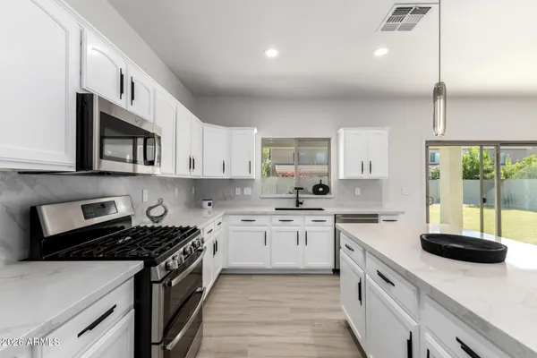 a kitchen with stainless steel appliances granite countertop a sink stove and cabinets