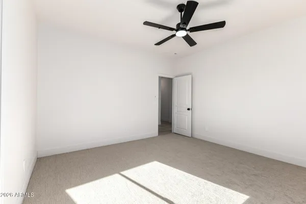 an empty room with a window and a ceiling fan