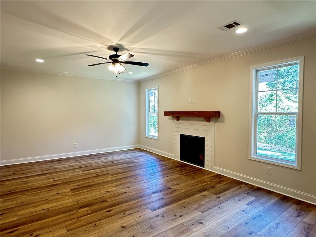 10 Lee Road Salem, AL 36874 - Photo 5 of 25 Wood-finish flooring, recessed lighting, ceiling fan, white trim, and a fireplace with a wood mantel