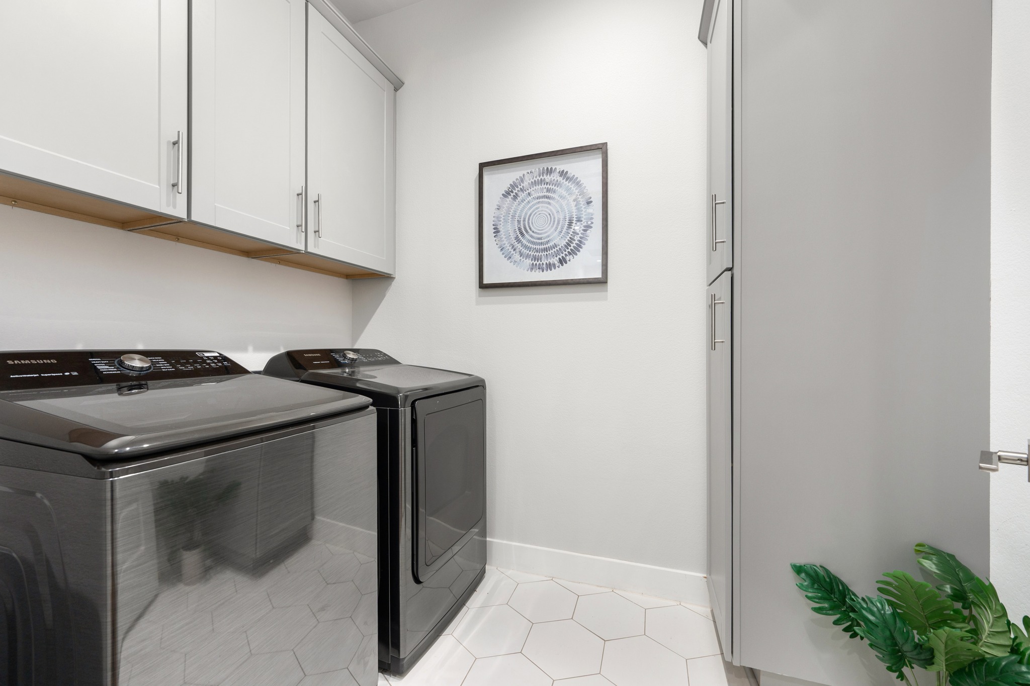 1409 Alegria Road, Unit A Austin, TX 78757 - Photo 12 of 24 Functional laundry room featuring overhead cabinetry and a modern washer and dryer set.