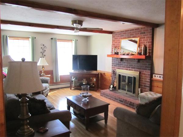 76 Emerson Road Walpole, MA 02032 - Photo 4 of 15 a living room with furniture a flat screen tv and a fireplace