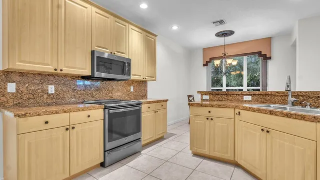 a kitchen with stainless steel appliances granite countertop a refrigerator and a stove
