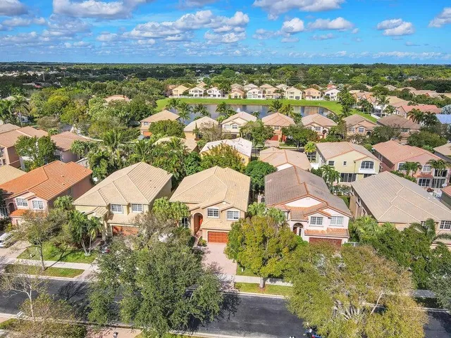 an aerial view of residential houses with outdoor space and lake view