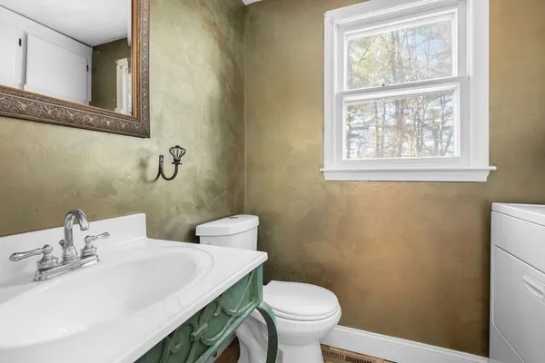 a bathroom with a sink a toilet and a window