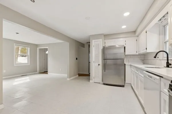 a view of a kitchen with refrigerator and a sink