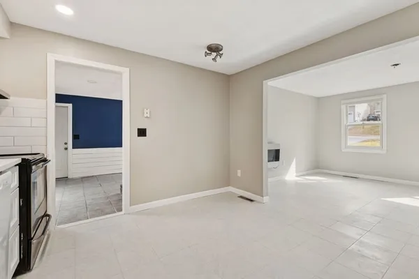 a view of an empty room with window and closet area