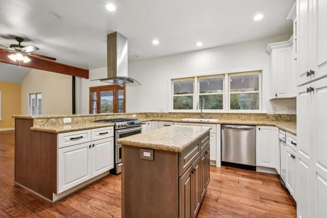 a kitchen with stainless steel appliances granite countertop a stove and a sink