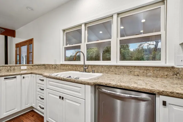 a kitchen with granite countertop a sink and a window