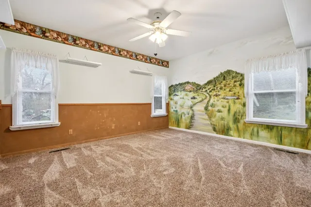 a view of a livingroom with a ceiling fan and window