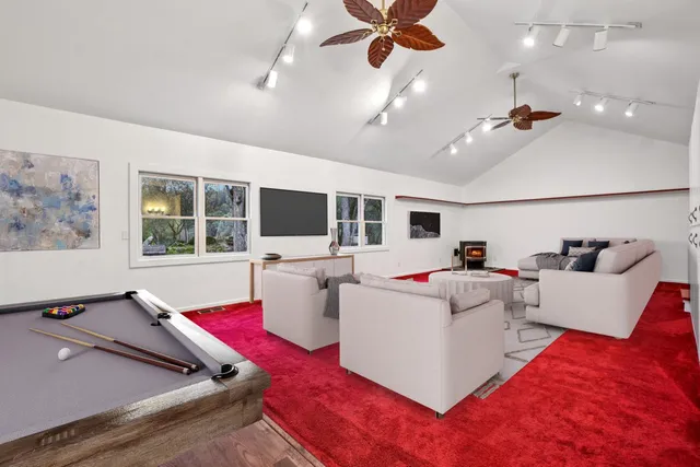 a living room with furniture ceiling window and a flat screen tv
