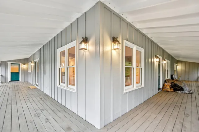 a view of a hallway with wooden floor and windows