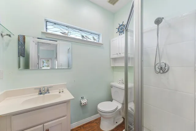 a bathroom with a toilet sink a mirror and shower