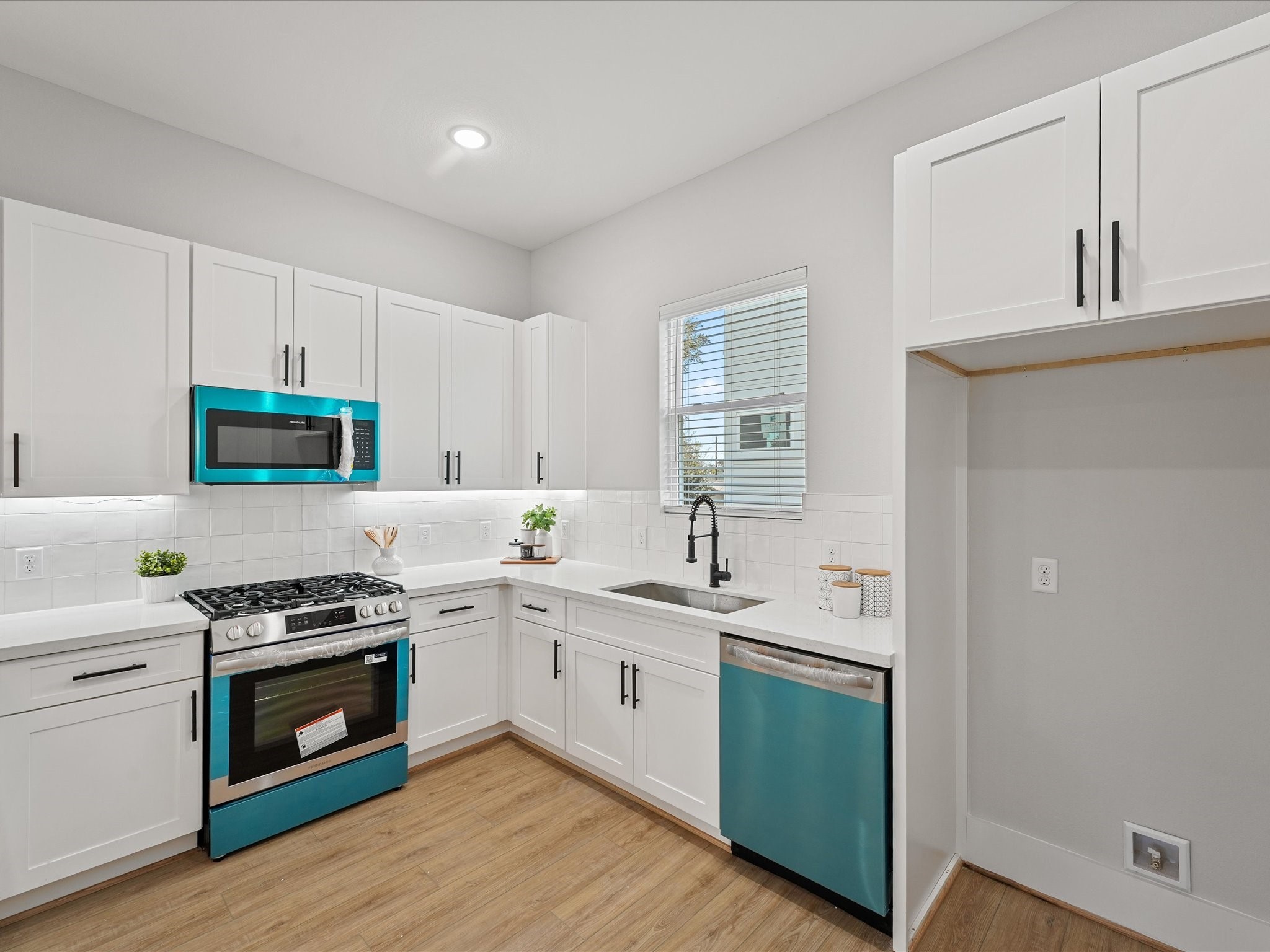 4812 Cochran Street Houston, TX 77009 - Photo 14 of 30 a kitchen with stainless steel appliances a white stove top oven sink and cabinets
