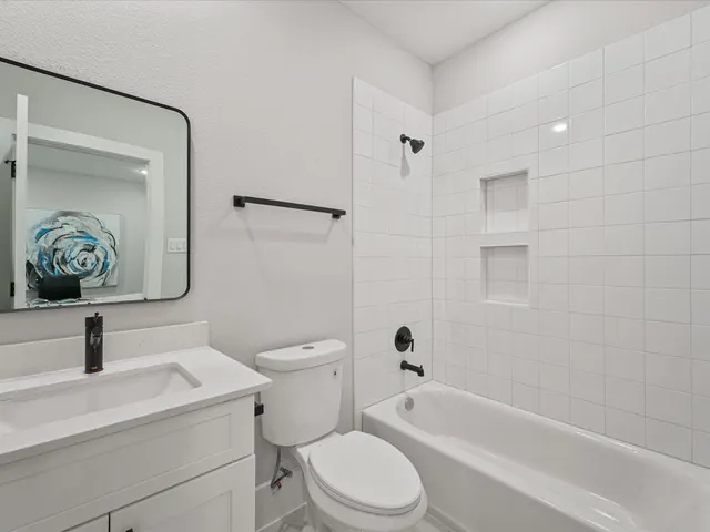 a bathroom with a toilet sink a mirror a vanity and bathtub