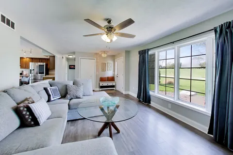 a living room with furniture a rug and a kitchen view