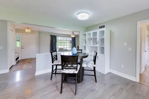 a kitchen with granite countertop stainless steel appliances a sink dishwasher a refrigerator cabinets and wooden floor