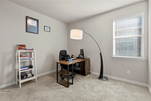 a view of a workspace with furniture and a window