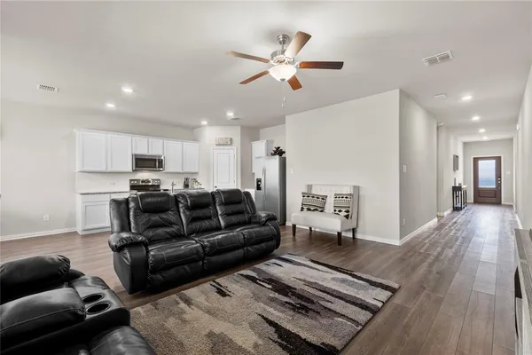a living room with furniture and a wooden floor