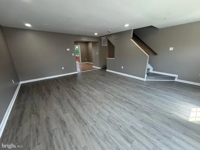 an empty room with wooden floor and window