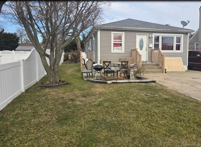 a front view of a house with a yard and seating space