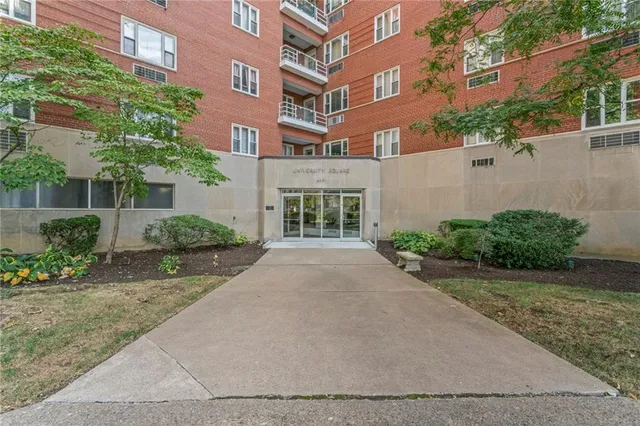 front view of a brick house with a yard