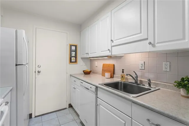 a kitchen with stainless steel appliances granite countertop white cabinets and a sink