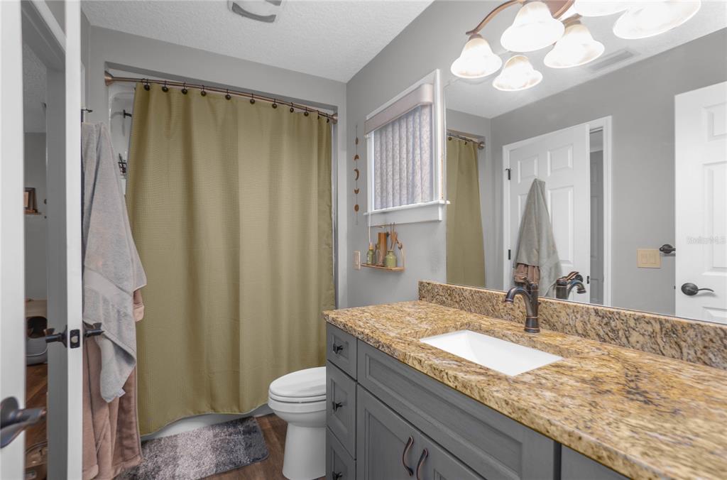 5466 West Tortuga Loop Lecanto, FL 34461 - Photo 26 of 41 a bathroom with a granite countertop sink toilet and shower